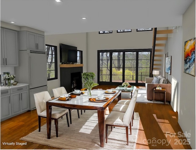 dining area featuring light wood-type flooring, a healthy amount of sunlight, a fireplace, and recessed lighting