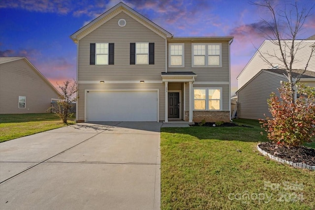 front of property with a garage and a yard