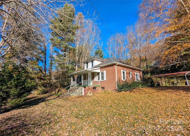 view of side of property featuring a porch and a yard