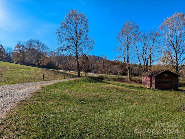 view of yard with a rural view and a storage shed