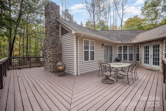 wooden deck featuring french doors and an outdoor fire pit