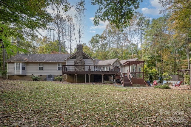 back of house featuring a deck and a lawn