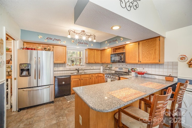 kitchen with a kitchen breakfast bar, kitchen peninsula, sink, and black appliances