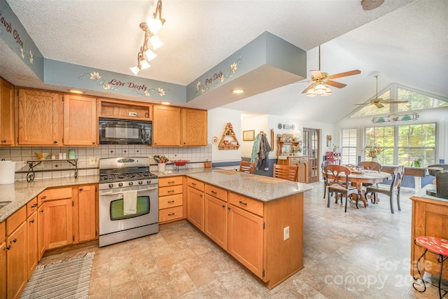 kitchen with tasteful backsplash, light stone counters, gas range, and kitchen peninsula