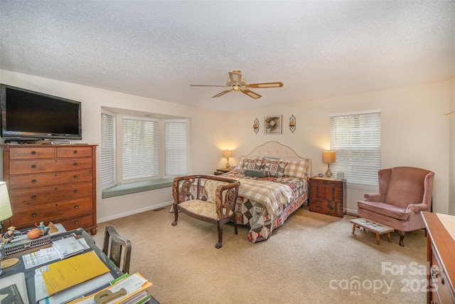 bedroom with ceiling fan, carpet flooring, and a textured ceiling