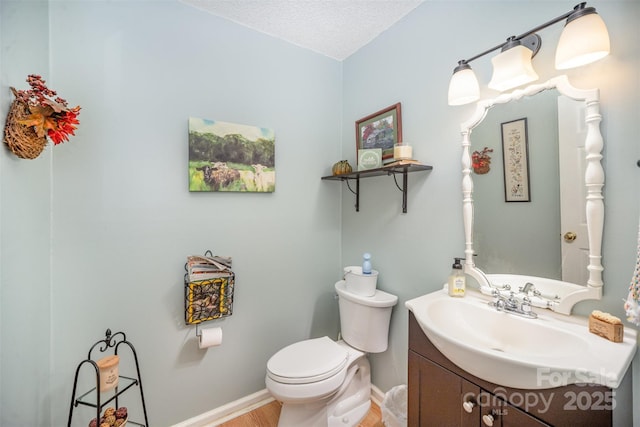 bathroom with vanity, a textured ceiling, and toilet