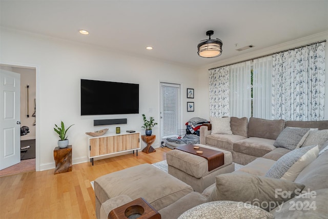 living room with ornamental molding and hardwood / wood-style floors