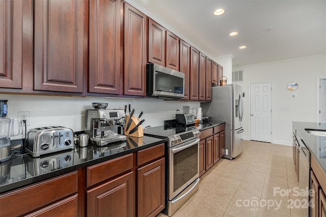 kitchen with crown molding, stainless steel appliances, and light tile patterned floors