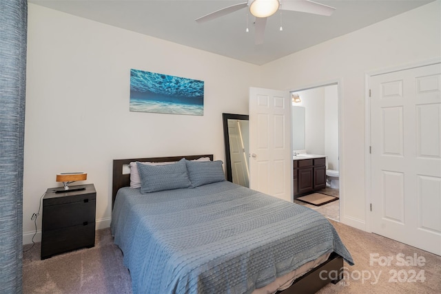 bedroom featuring light carpet, ensuite bath, and ceiling fan