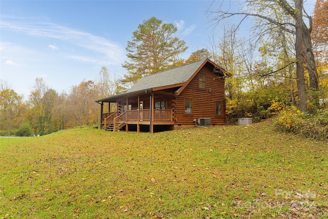 exterior space with a wooden deck, a yard, and cooling unit