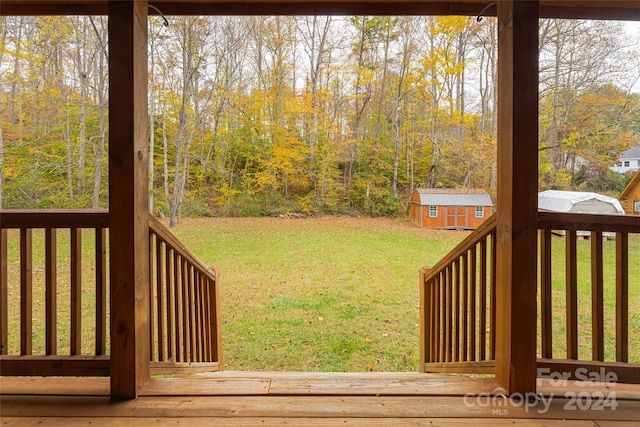 wooden deck featuring a yard and a storage shed