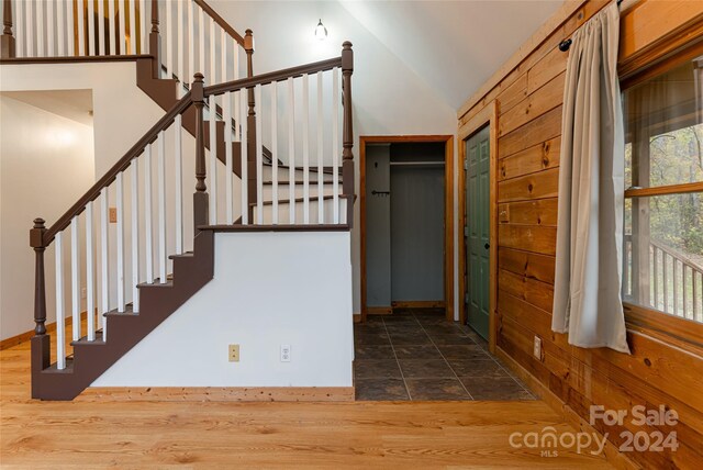 stairway featuring wood-type flooring and vaulted ceiling