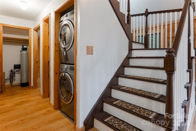 stairway featuring hardwood / wood-style floors and stacked washing maching and dryer