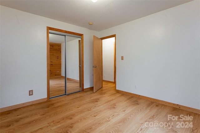 unfurnished bedroom with a closet and light wood-type flooring