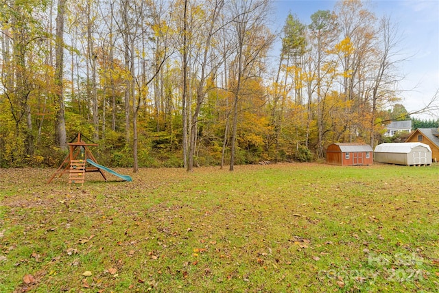 view of yard featuring a storage unit and a playground