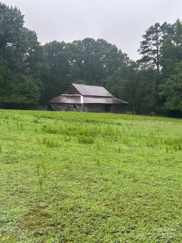 view of yard with a rural view and an outdoor structure