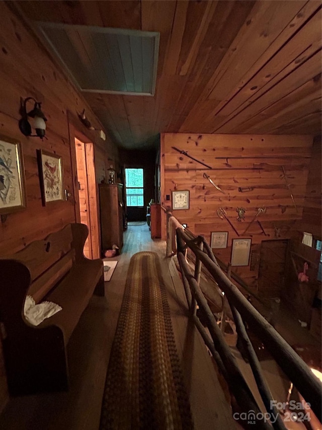 hallway featuring hardwood / wood-style flooring, wooden walls, and wooden ceiling