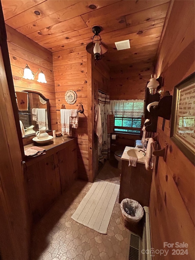 bathroom with toilet, wood walls, vanity, and wooden ceiling