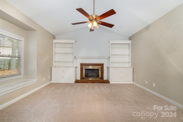 unfurnished living room with carpet, a brick fireplace, ceiling fan, and lofted ceiling