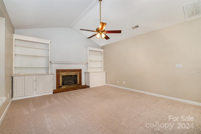 unfurnished living room featuring carpet flooring, ceiling fan, a fireplace, and vaulted ceiling