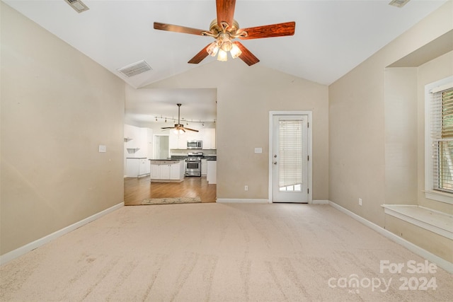 unfurnished living room with ceiling fan, light colored carpet, and vaulted ceiling