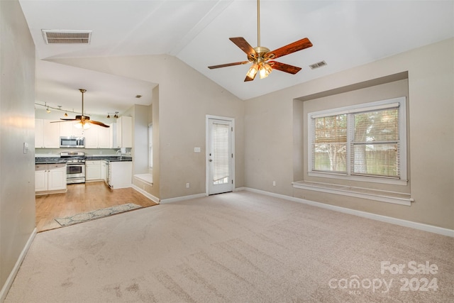 unfurnished living room with light colored carpet, ceiling fan, lofted ceiling, and sink