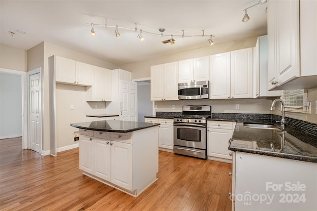 kitchen featuring white cabinets, a center island, sink, and stainless steel appliances