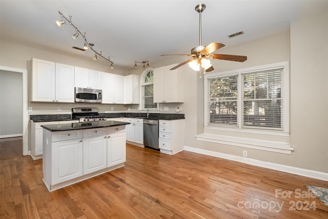 kitchen with white cabinets, appliances with stainless steel finishes, and light hardwood / wood-style flooring