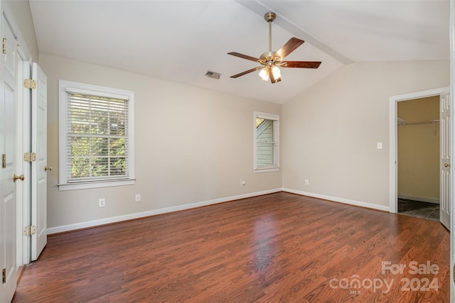 unfurnished bedroom featuring vaulted ceiling, ceiling fan, a spacious closet, dark hardwood / wood-style floors, and a closet