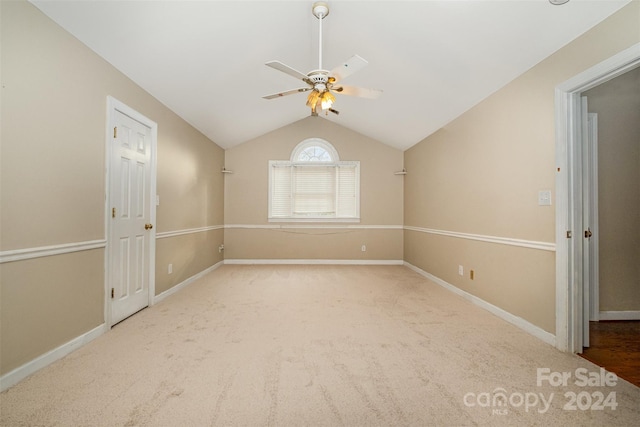 empty room featuring ceiling fan, lofted ceiling, and carpet floors