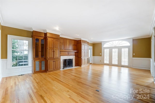 unfurnished living room with light wood-type flooring and ornamental molding