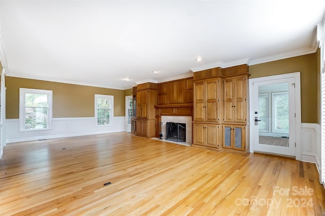 unfurnished living room featuring crown molding and light hardwood / wood-style flooring