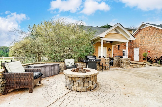 view of patio / terrace with an outdoor bar, a jacuzzi, ceiling fan, a grill, and an outdoor fire pit