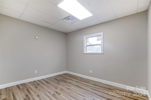 unfurnished room featuring a paneled ceiling and light hardwood / wood-style flooring