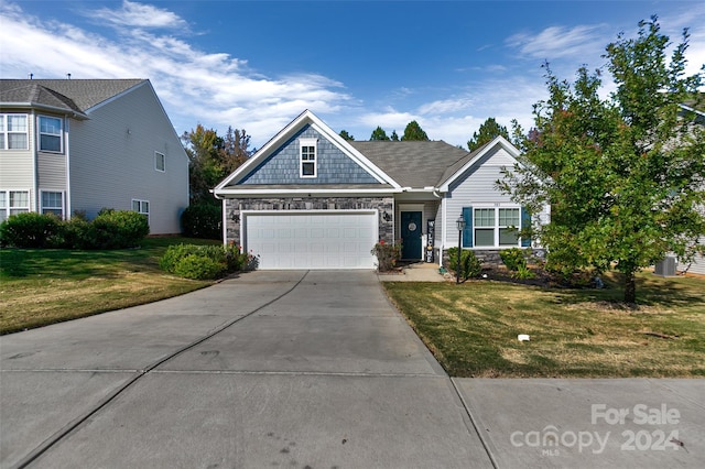 craftsman house with a front lawn and a garage