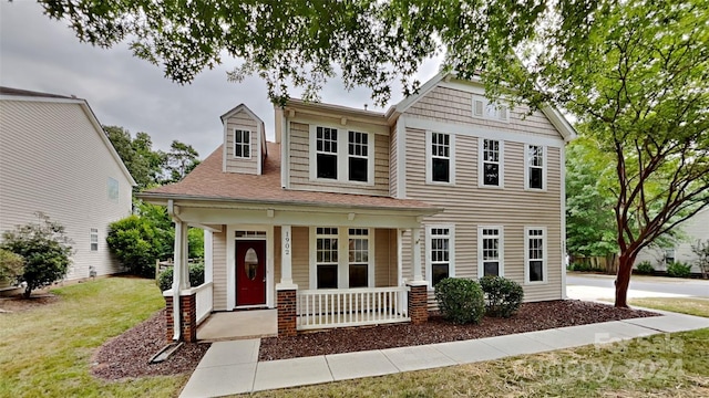 view of front of house featuring covered porch and a front yard