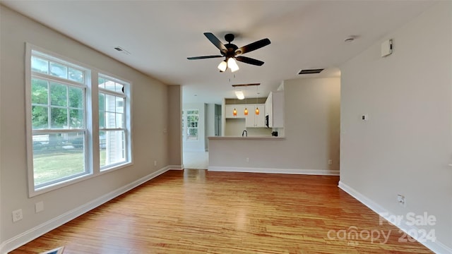 unfurnished living room featuring light hardwood / wood-style floors, plenty of natural light, and ceiling fan