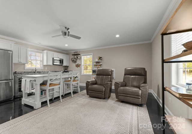 interior space featuring ceiling fan, plenty of natural light, and ornamental molding