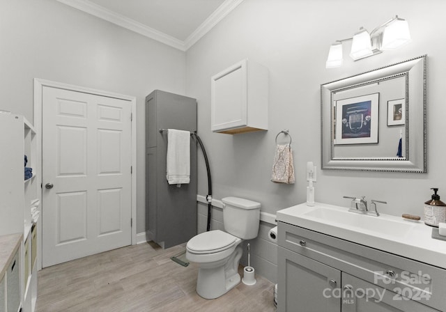 bathroom with toilet, vanity, hardwood / wood-style floors, and crown molding