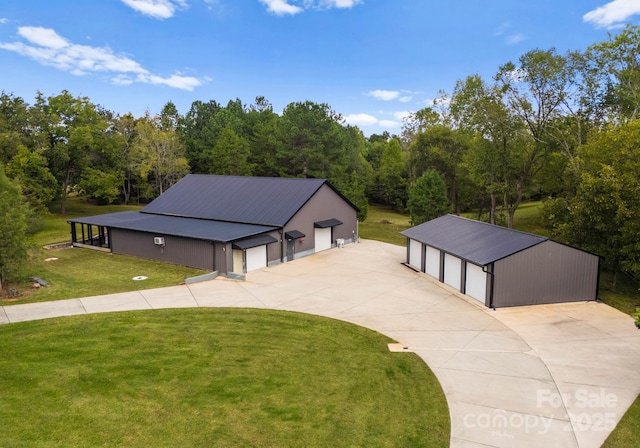 view of front of house with a garage, an outdoor structure, and a front yard