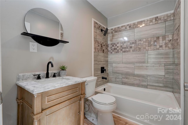 full bathroom with toilet, vanity, wood-type flooring, and tiled shower / bath