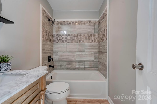 full bathroom with toilet, vanity, hardwood / wood-style floors, and tiled shower / bath