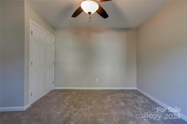 carpeted spare room with ceiling fan