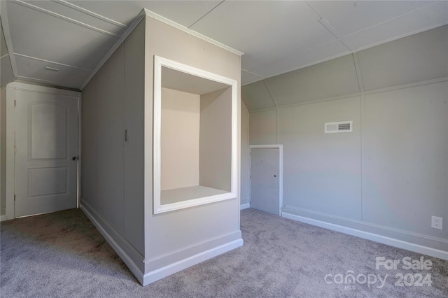 bonus room with lofted ceiling and light colored carpet