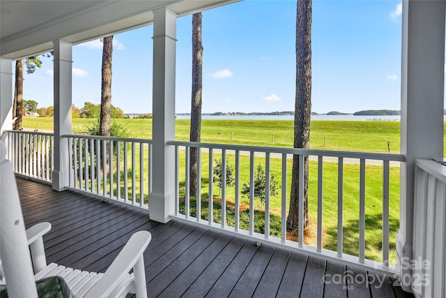 wooden deck featuring a yard and a water view