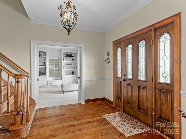 foyer with a chandelier, light hardwood / wood-style flooring, and ornamental molding