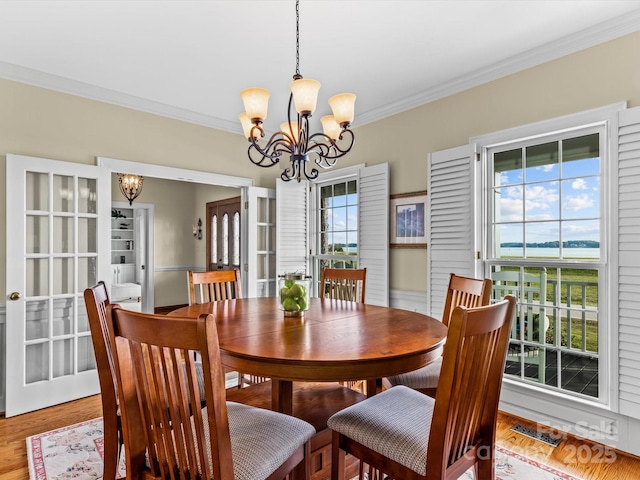 dining space featuring a notable chandelier, crown molding, and a wealth of natural light