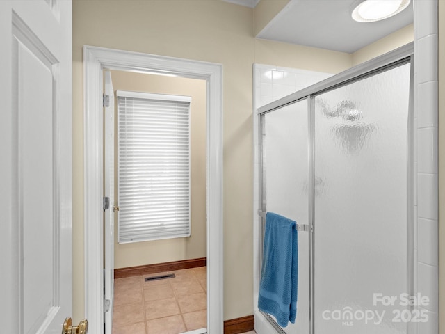 bathroom with tile patterned flooring and a shower with shower door