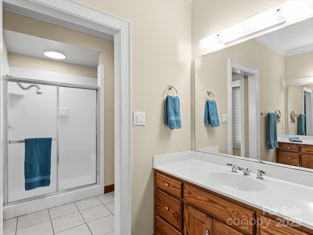 bathroom with tile patterned floors, vanity, a shower with shower door, and crown molding