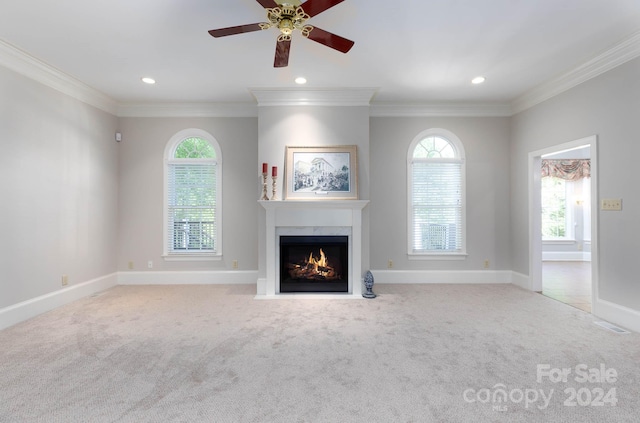 unfurnished living room with crown molding, a healthy amount of sunlight, and light carpet